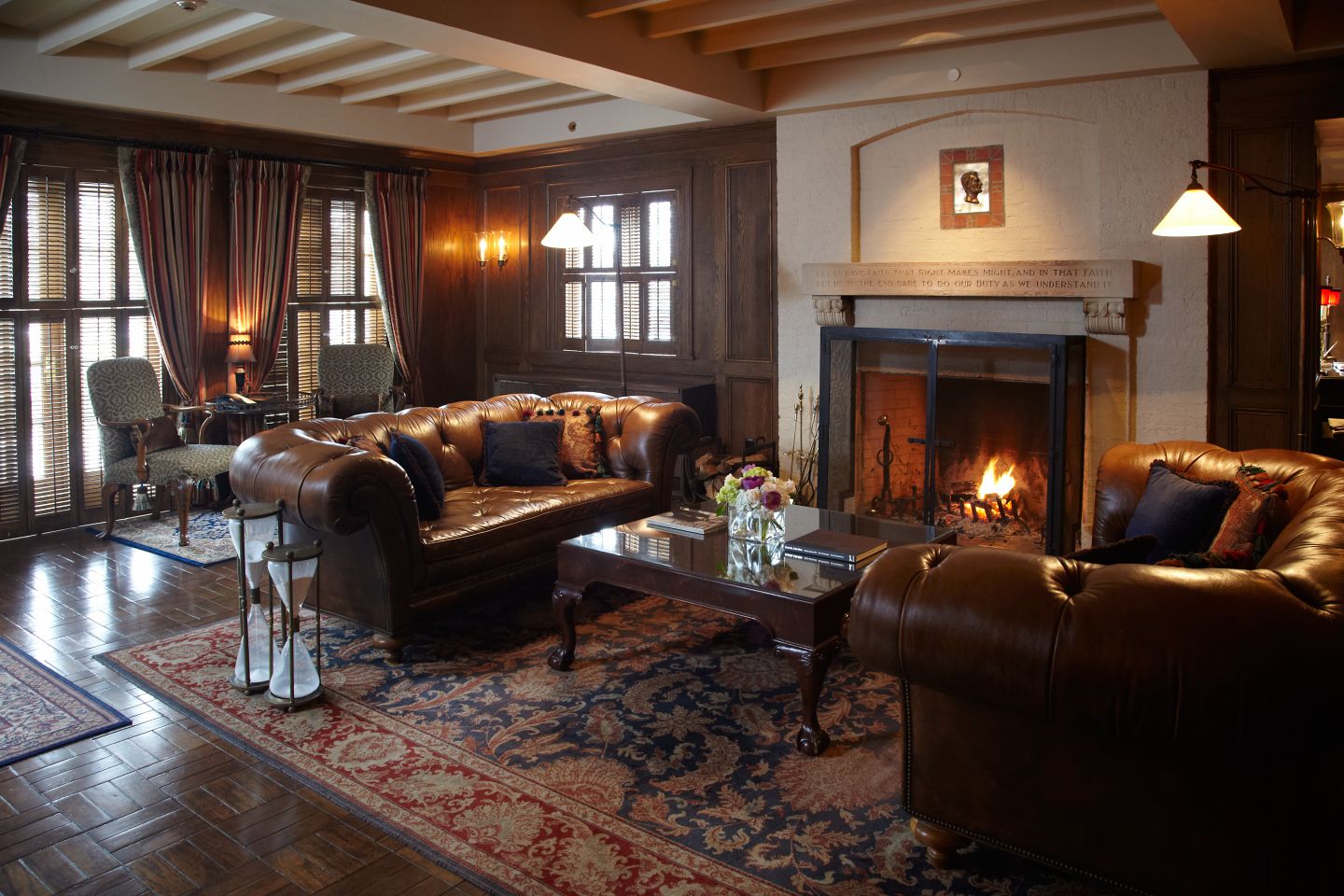 Interior of the American Club facing the fireplace which is surrounded by leather couches