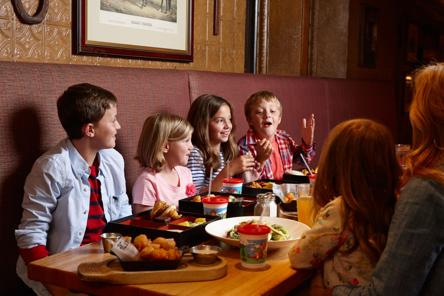 a dining table with food and children sitting around it