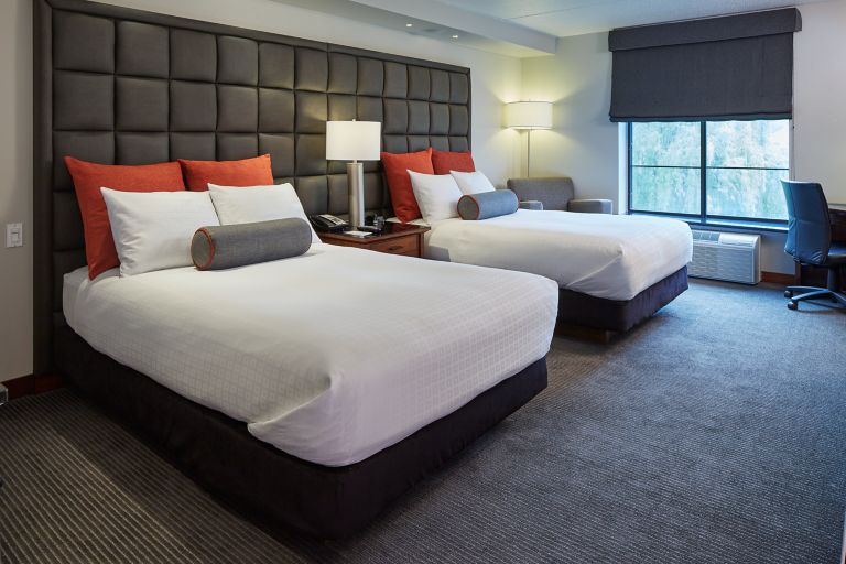 Two queen beds against the wall inside a Prairie room at The Inn on Woodlake