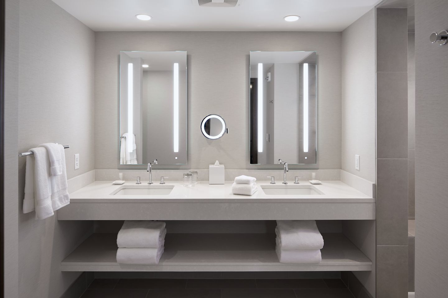 Inside the well-lit bathroom with double vanities at the Inn on Woodlake