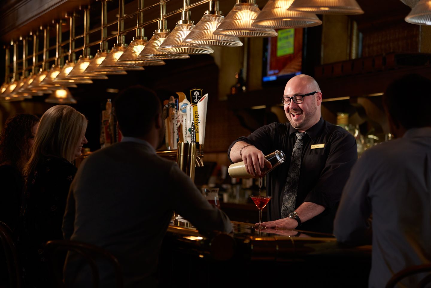 a bartender making a red martini 