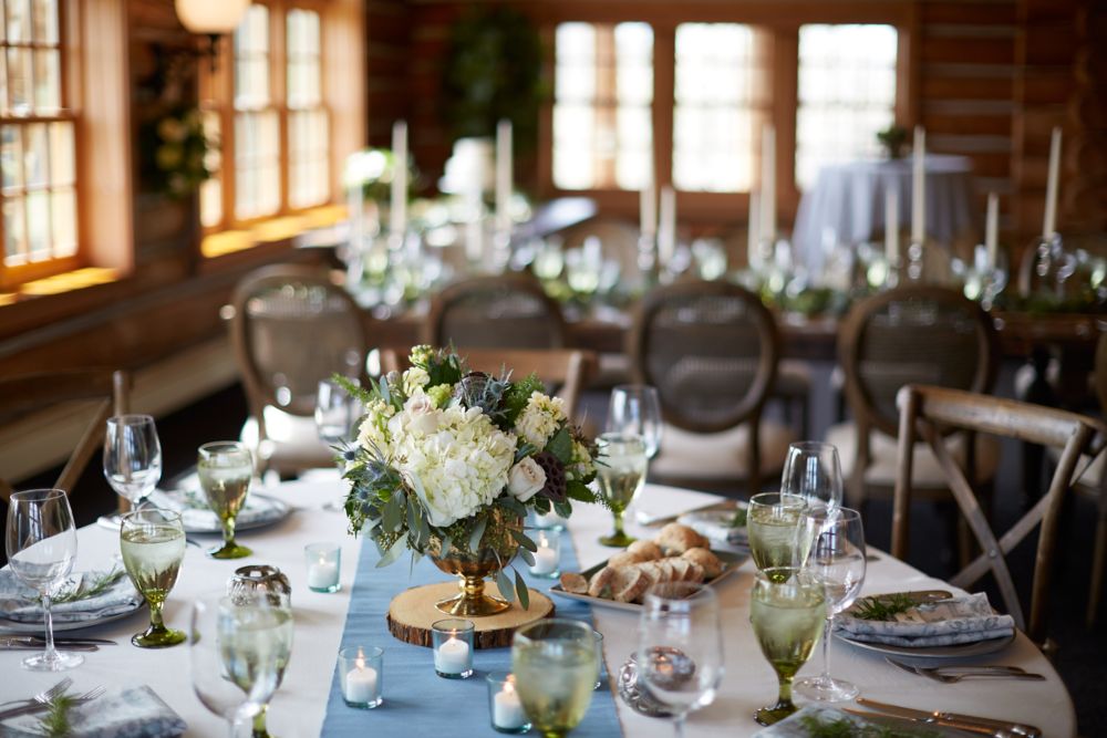 a dining table setting ready for a wedding focusing on the flower centerpiece