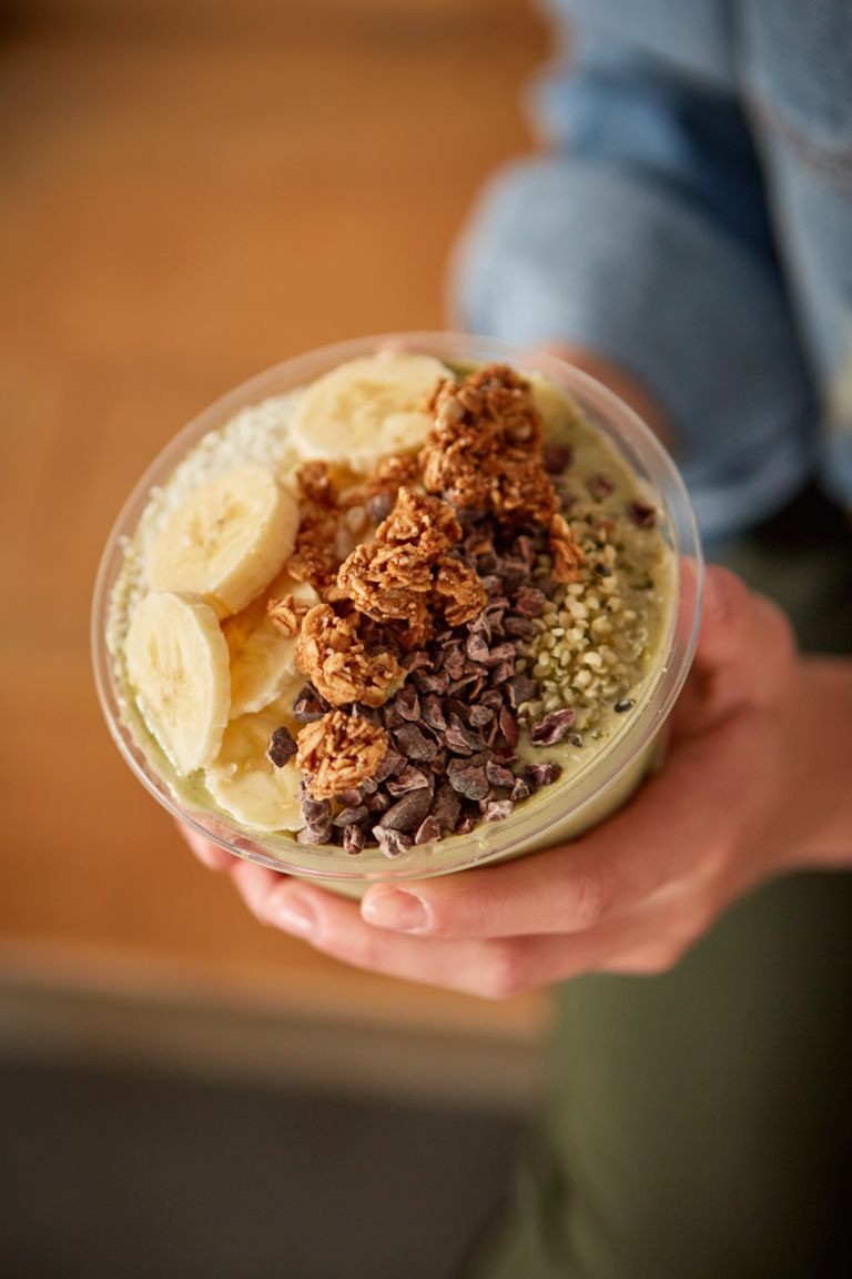 hands holding a smoothie bowl