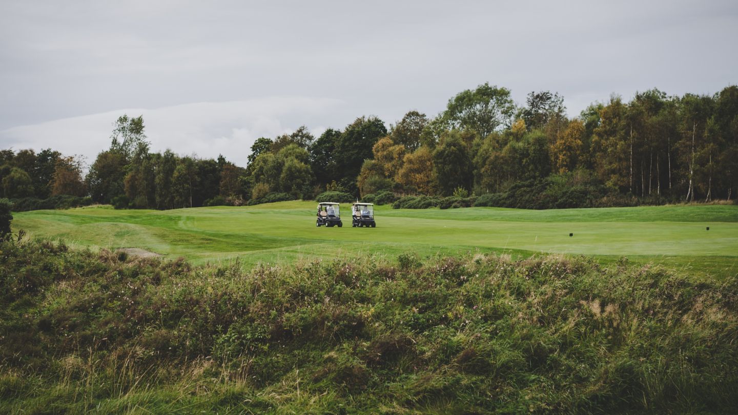 Two golf buggies with golfers on the Duke's course
