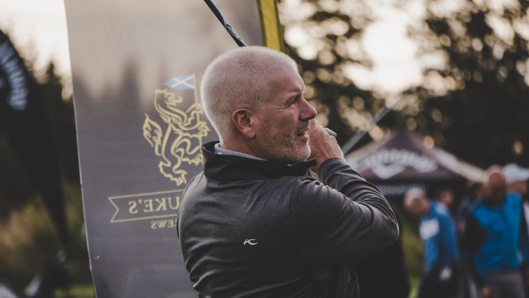 Close up of male golfer teeing off