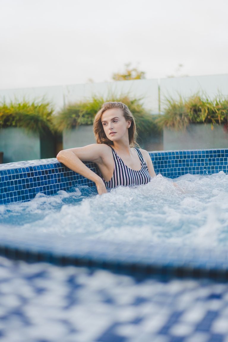Young woman relaxing in outdoor hot tub at Kohler Waters Spa, St Andrews