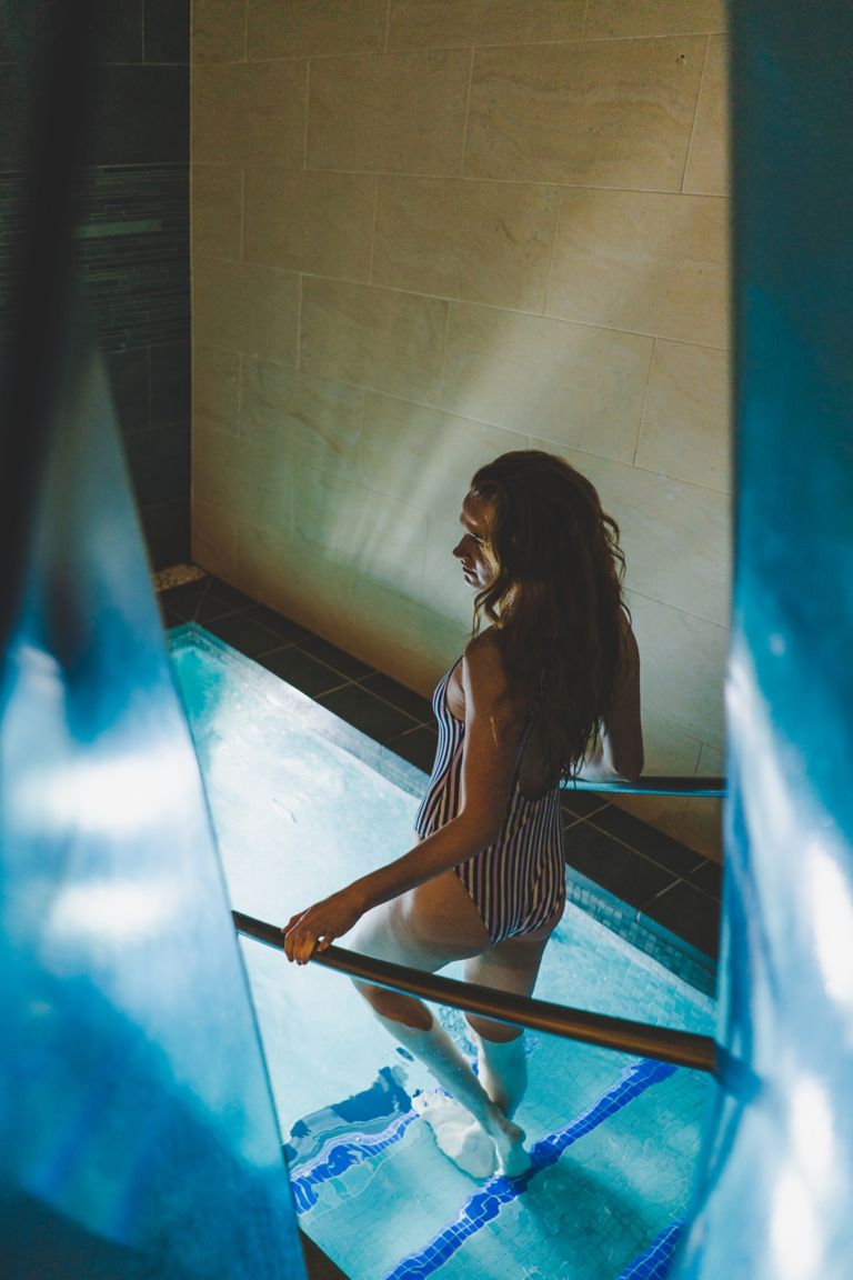Young woman walking into plunge pool at Kohler Waters Spa, St Andrews