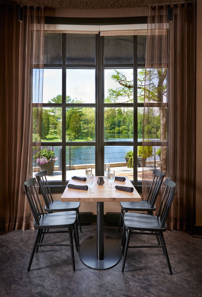 a table with glasses overlooking Wood Lake through a window