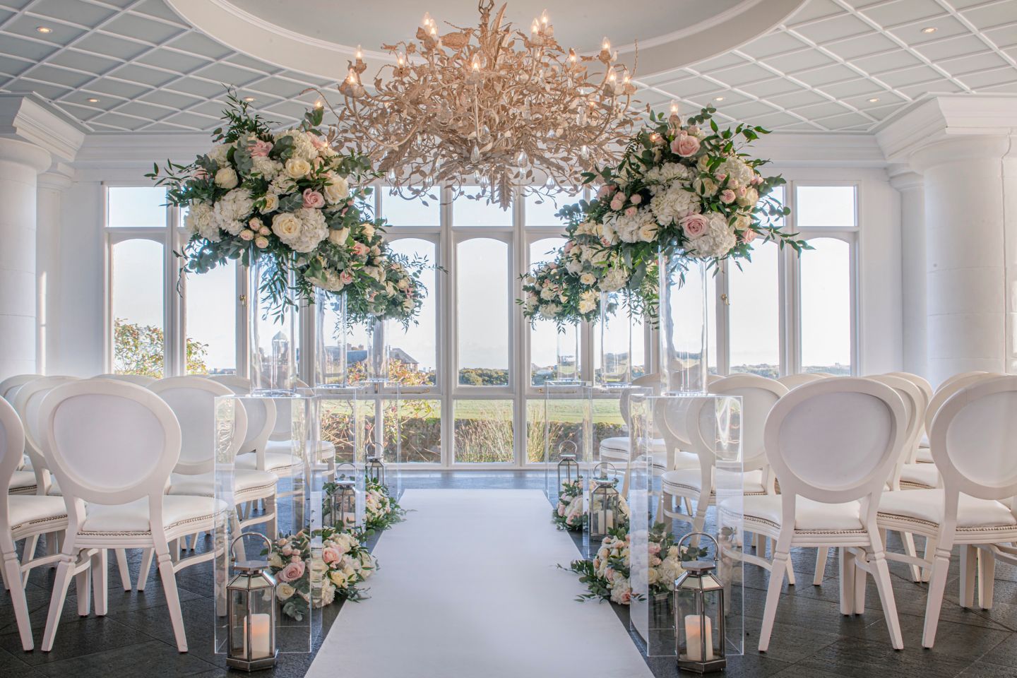 Wedding ceremony set up with flower arrangement in the Conservatory at the Old Course Hotel, Golf Resort & Spa looking out over the world famous golf course.