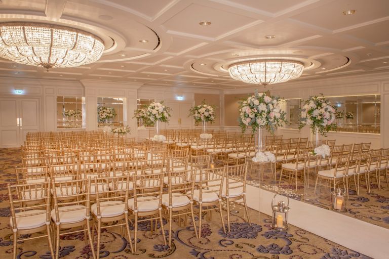 Wedding ceremony set up with flower arrangement and chiavari chairs in the grand Ballroom venue space at the Old Course Hotel, Golf Resort & Spa.