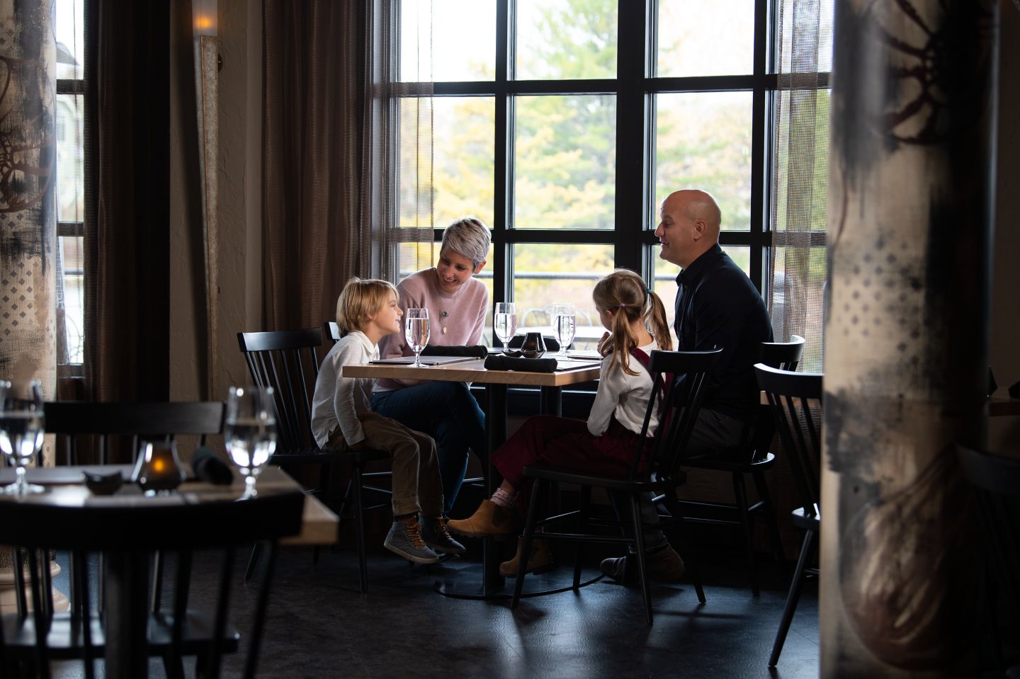 a family sitting talking at a dining table at Taverne on Woodlake