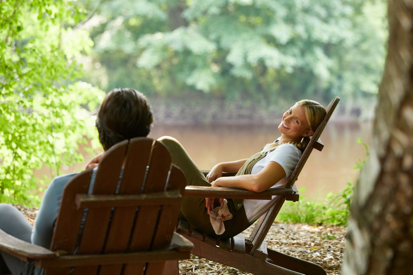 A woman enjoying the weather sitting by a river