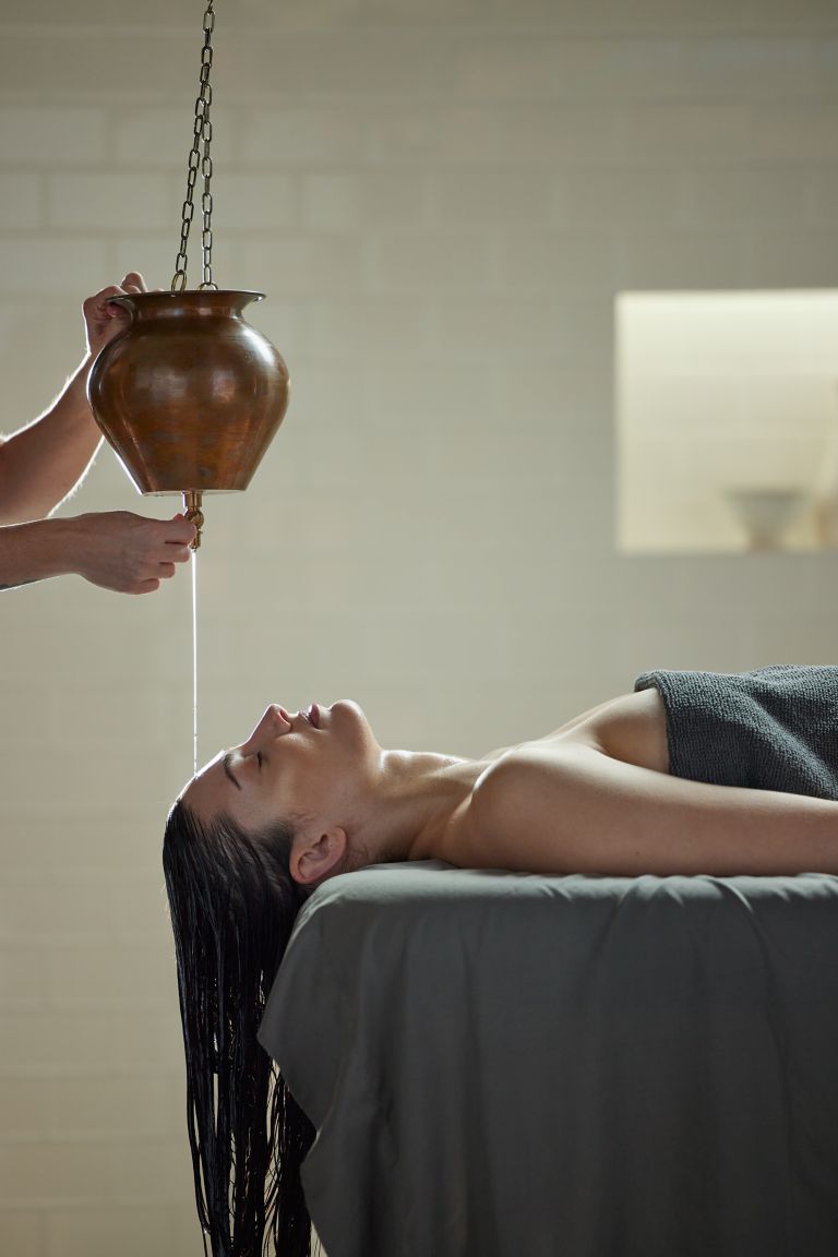 a lady recieving a massage with tuning bowls and rainshower