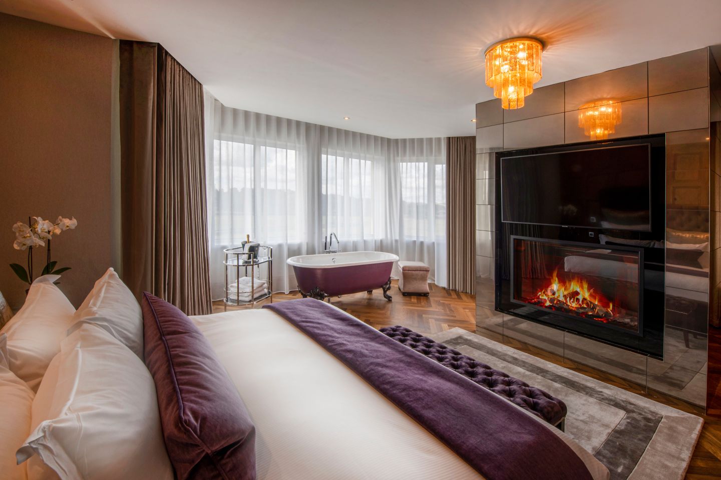 The Penthouse suite bedroom at the Old Course Hotel, St Andrews, with a fireplace and freestanding bath