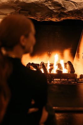 a couple enjoying wine by a fireplace