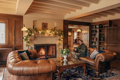 A man reading sitting by the fire