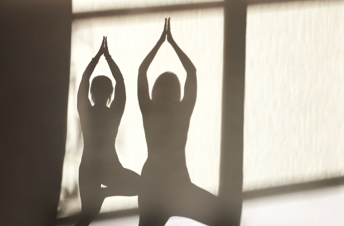 shadows of two people practicing yoga