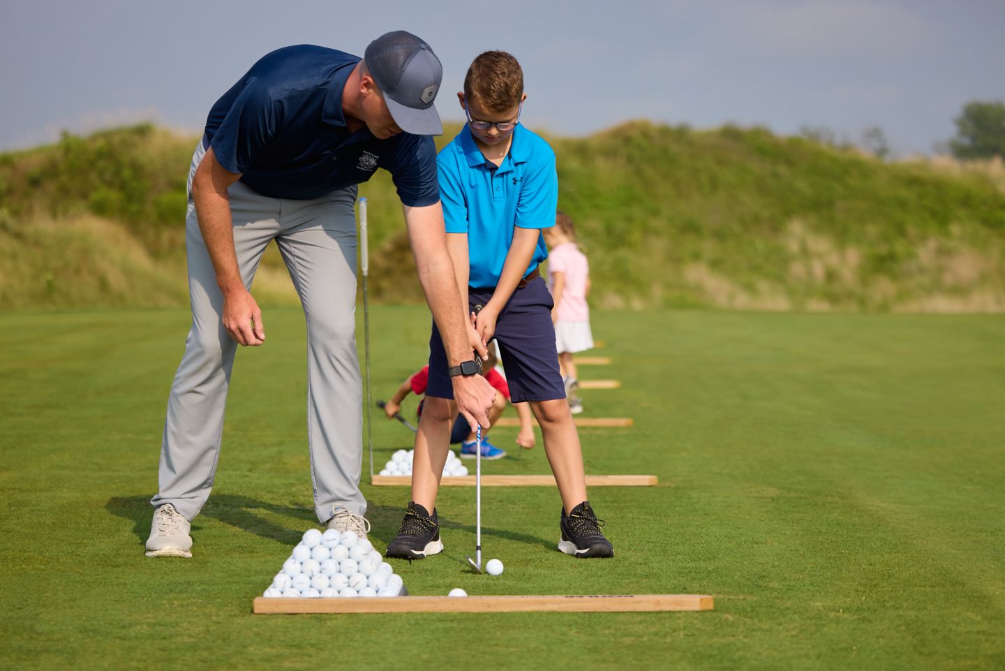 junior golfer receiving golf swing instruction