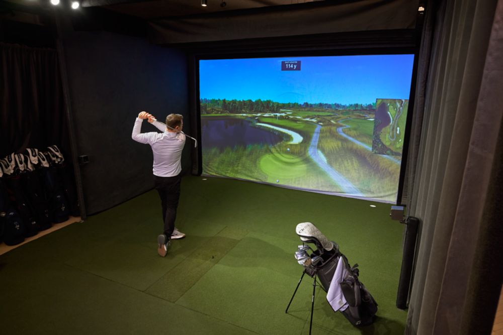 a golfer swinging in a simulator