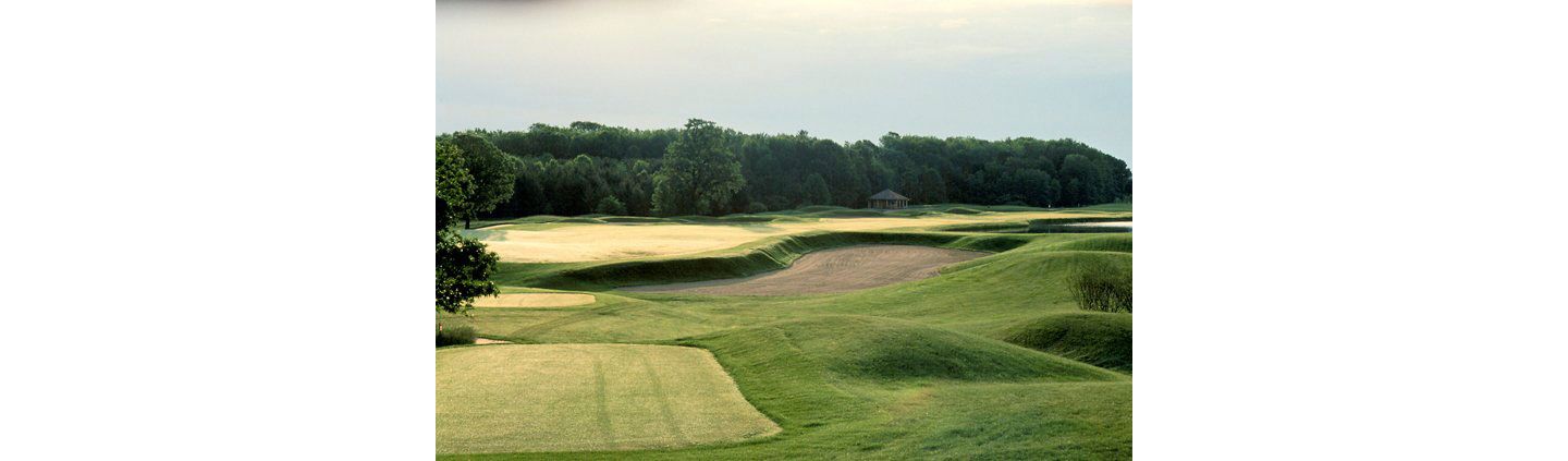 Hole 9 of the Meadow Valleys course with a sand trap and the green in the distance. 
