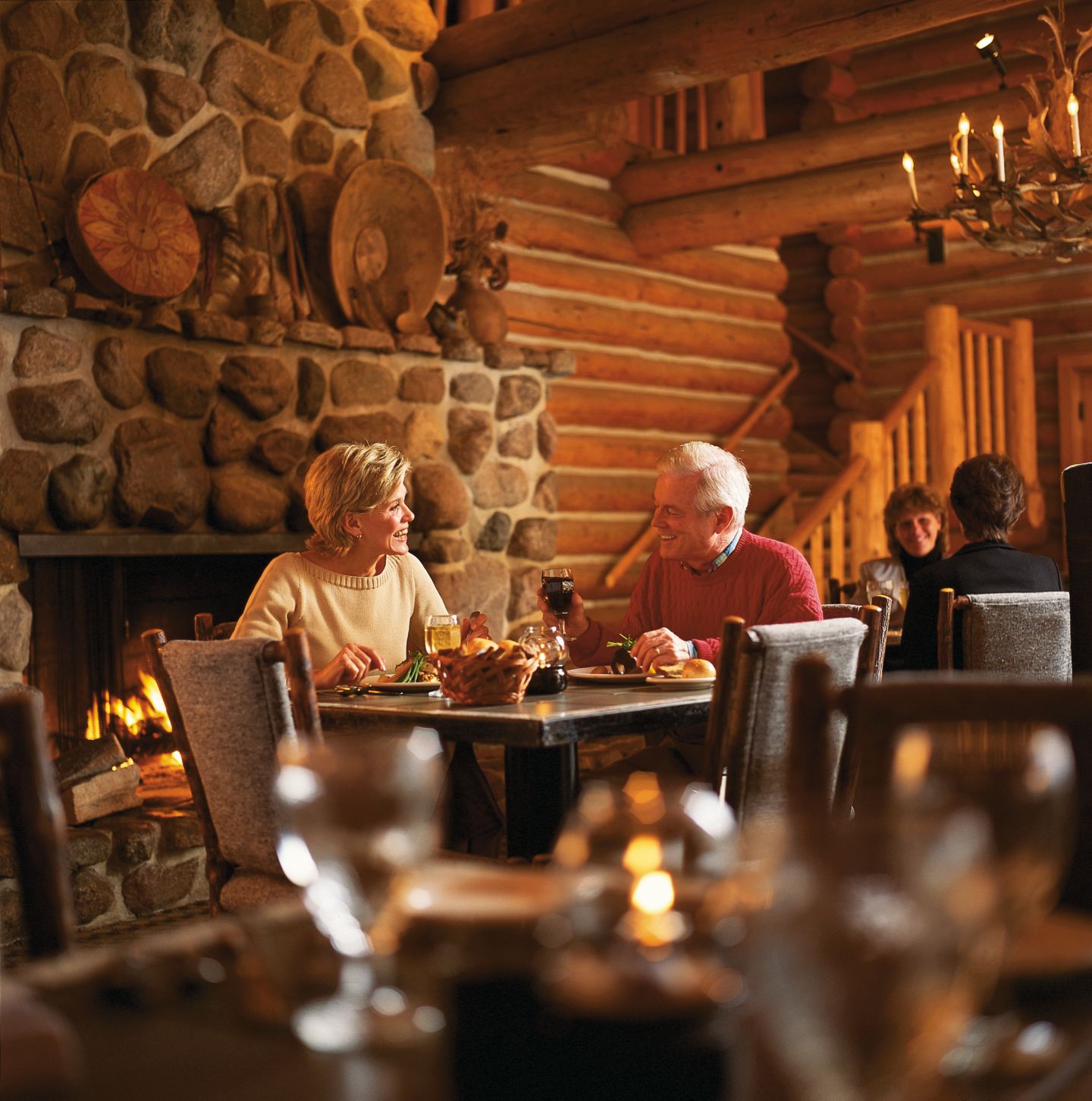 a couple having a meal at a table in front of a lit fireplace at Blackwolf Run