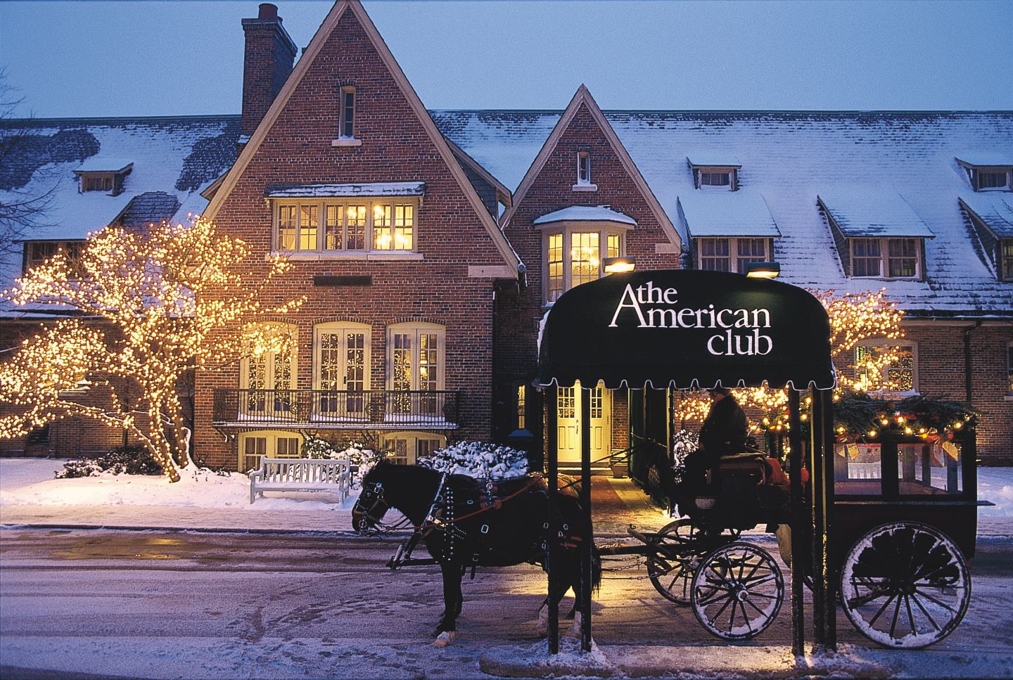 a horse and carriage in front of The American Club