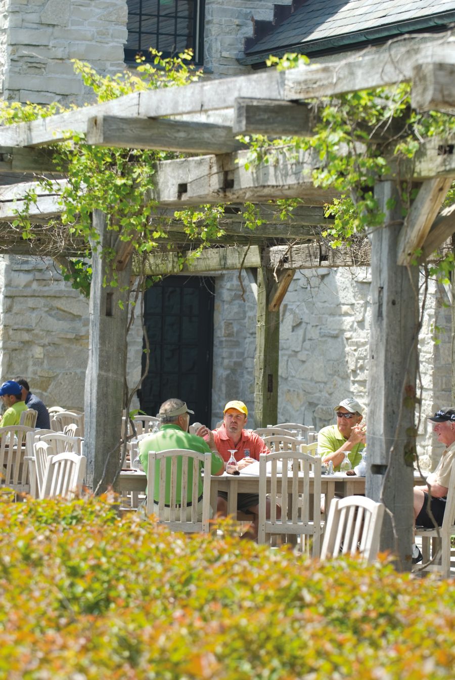 golfers sitting at a dining table on the outdoor terrace