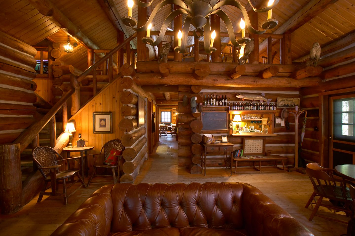 the interior of a log cabin with a leather couch