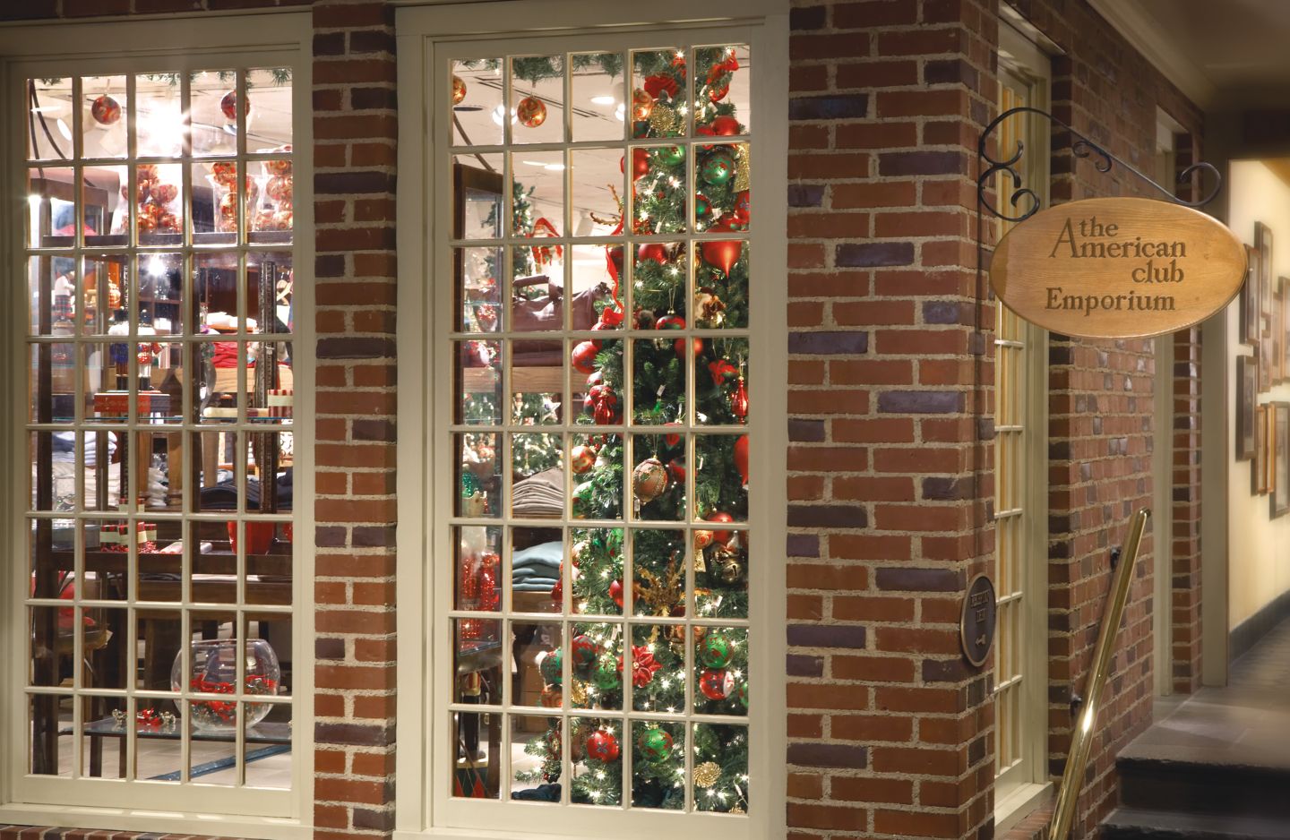 Exterior of Emporium gift shop looking through a window at a holiday tree