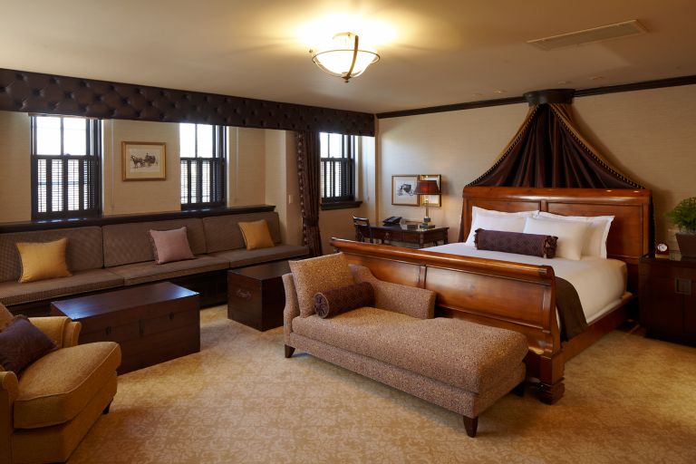 a king bed and sitting area in a carriage house governor suite