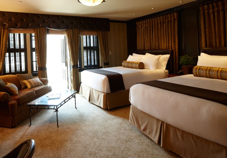 two beds in a deluxe room at the carriage house