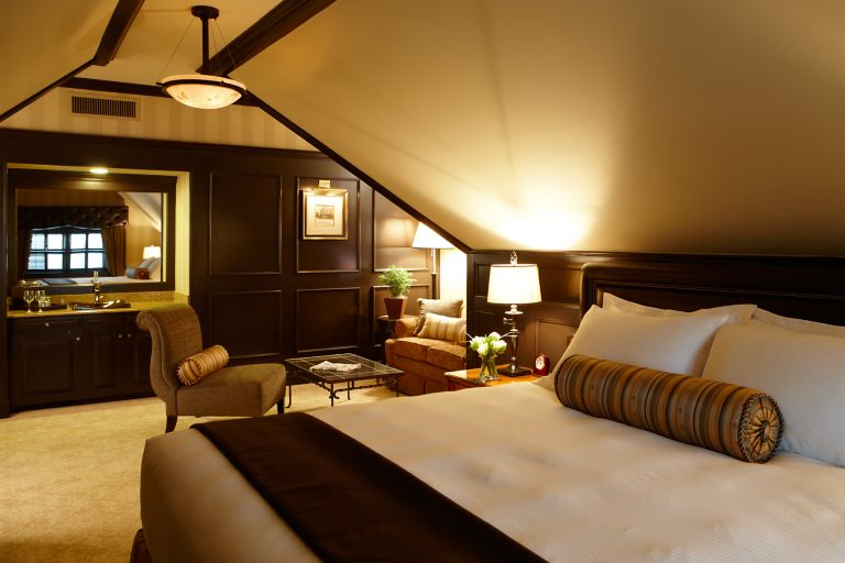 a bed in a deluxe room at the carriage house