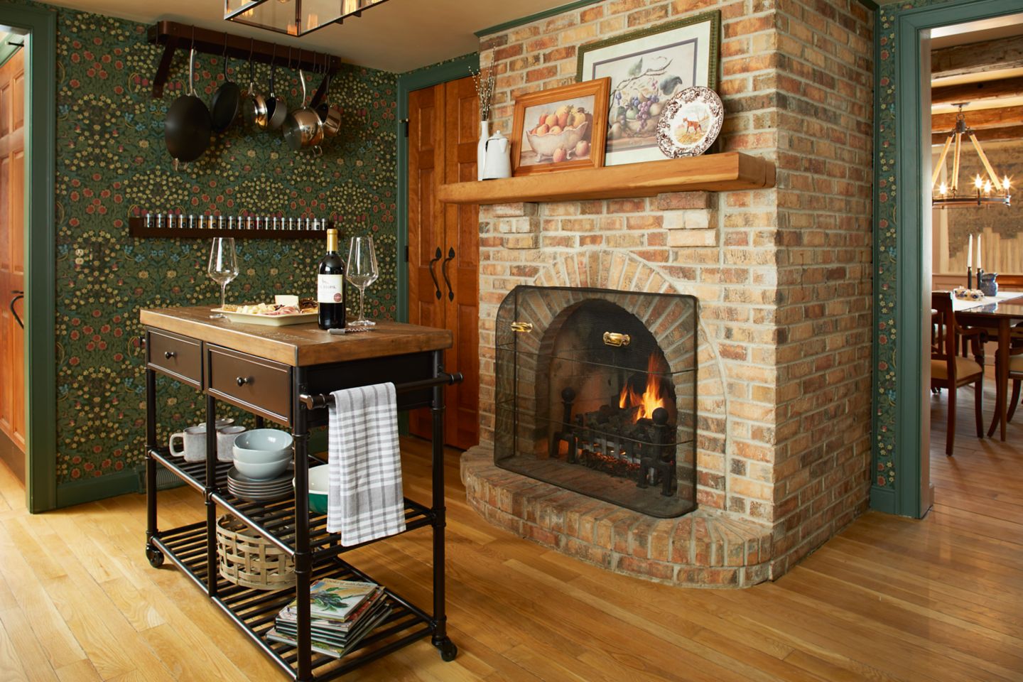 A rustic kitchen fireplace with a table in front of it holding wine and a charcuterie board