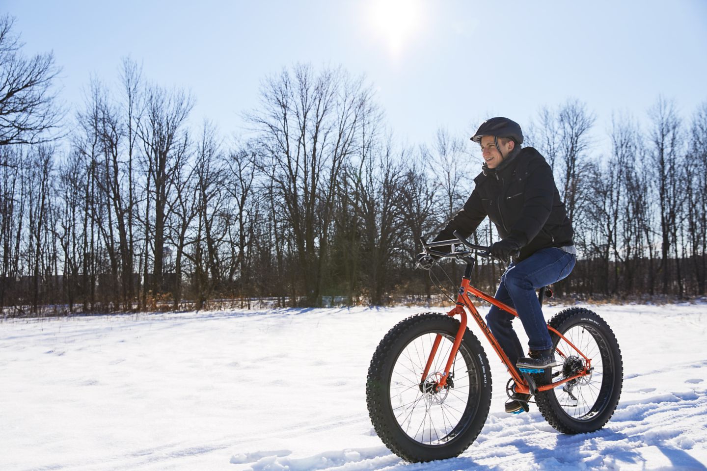 one person using a fat tire bike in the snow under the sun