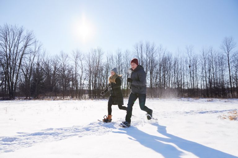 a couple snowshoeing on a sunny day