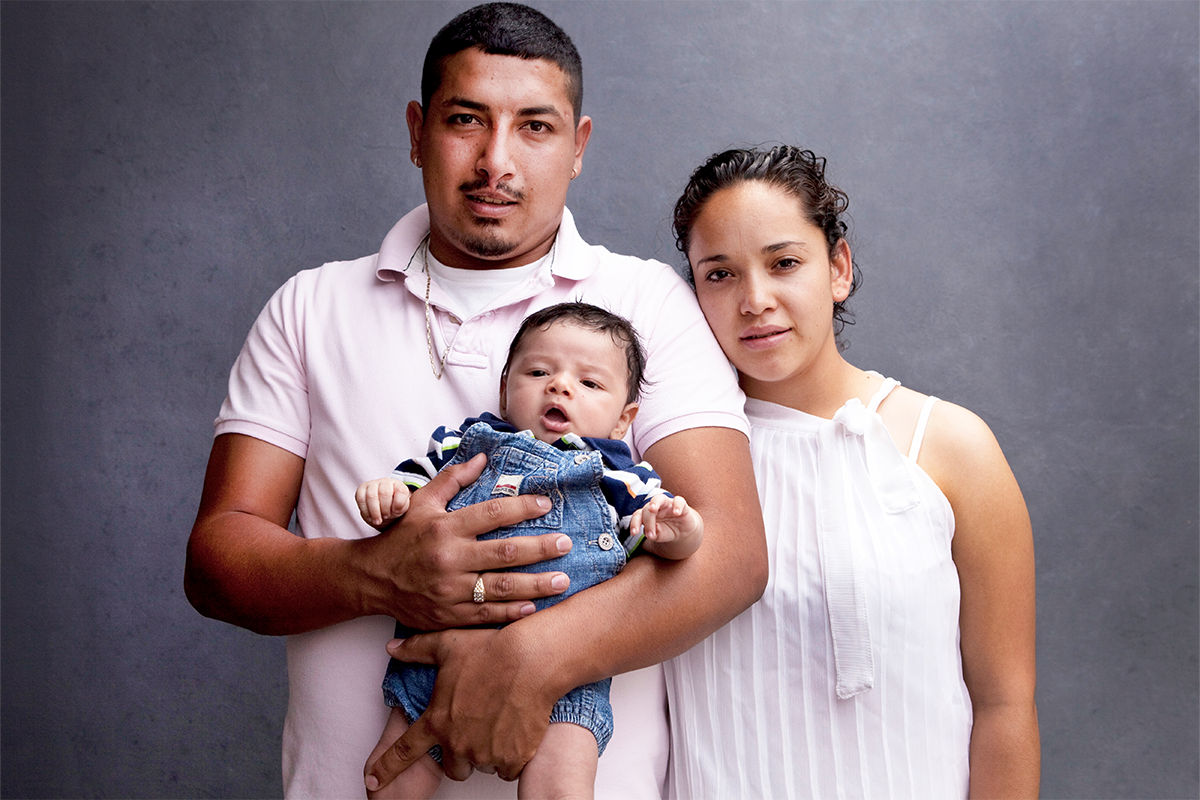 A young hispanic family of three taking a family portrait. 