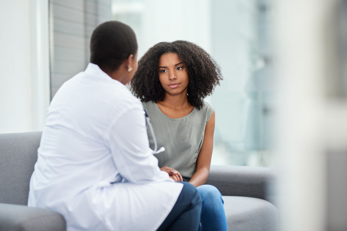 Patient sitting in a doctors office talking to a doctor