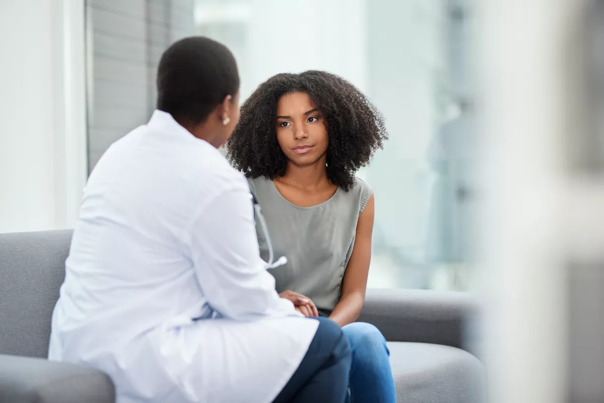 Provider talking to a young adult patient on a couch