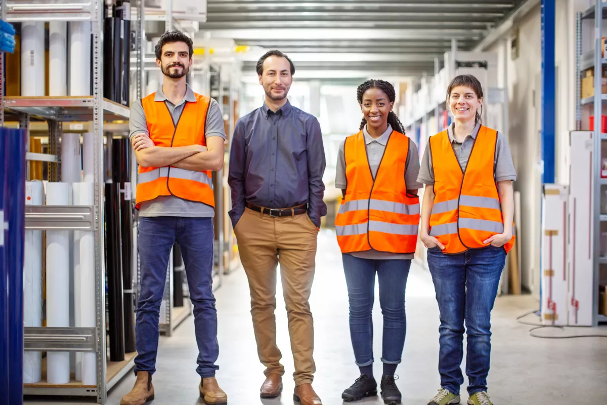 Group of four factory workers in a warehouse