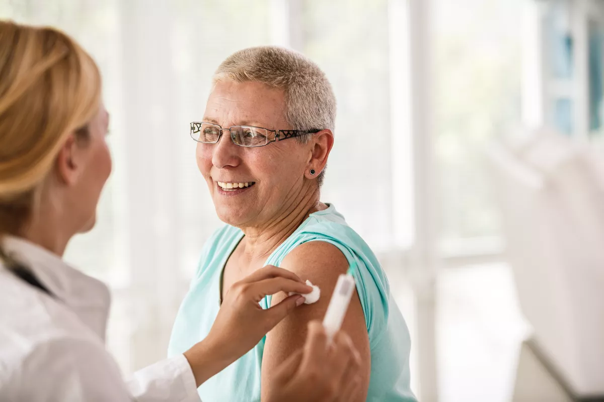 Older woman getting a vaccine.