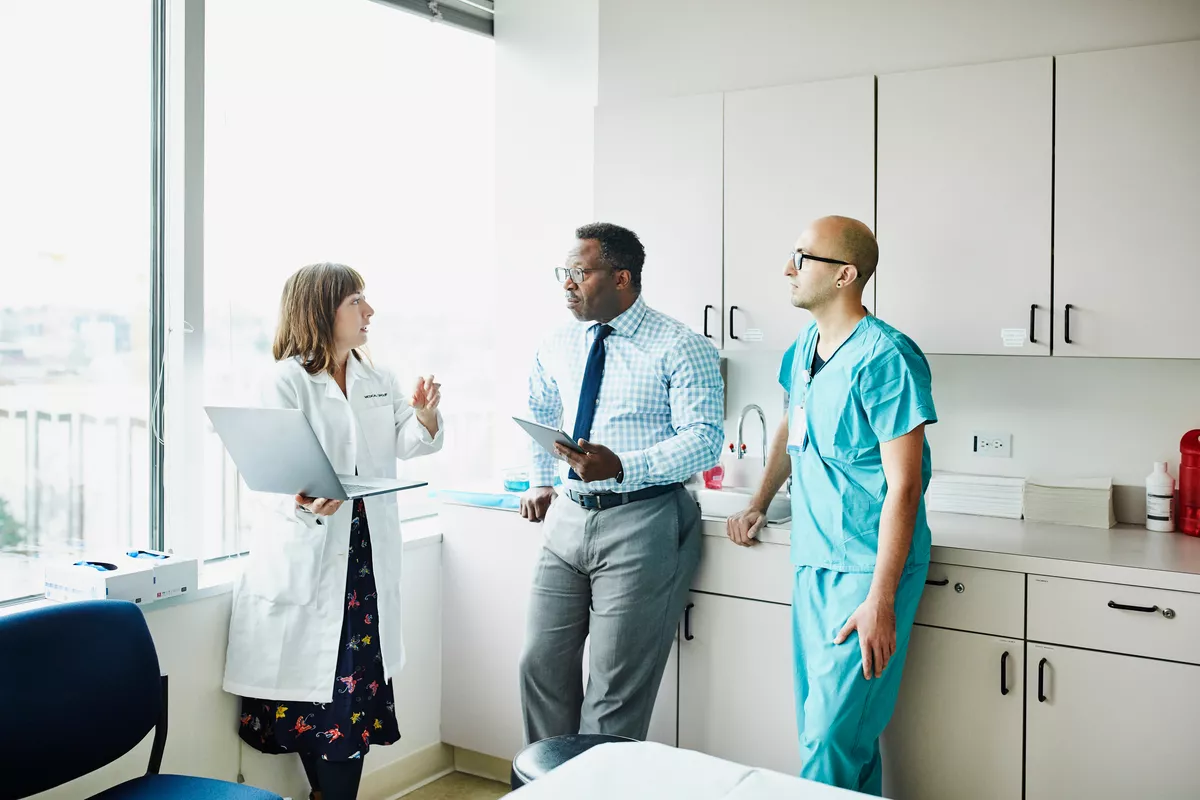 Three providers standing in a break room talking