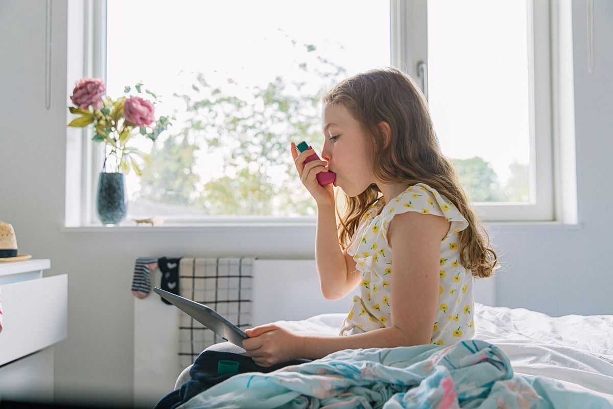 Young girl taking a dose from her inhaler