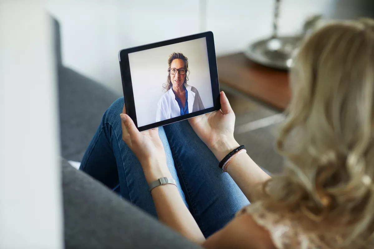 Proveedor en la pantalla de la tableta de un paciente mientras realiza una videollamada