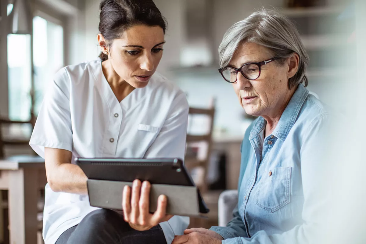 Provider and woman sitting down. They are going over results on a tablet