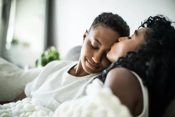 Gender Diverse couple snuggling on a couch