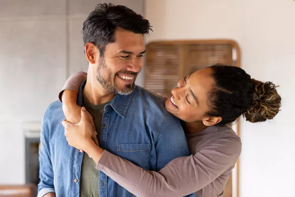 happy couple hugging in their living room