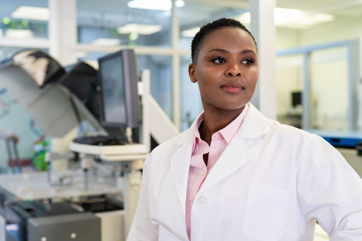 Scientist standing confidently in front of a machine