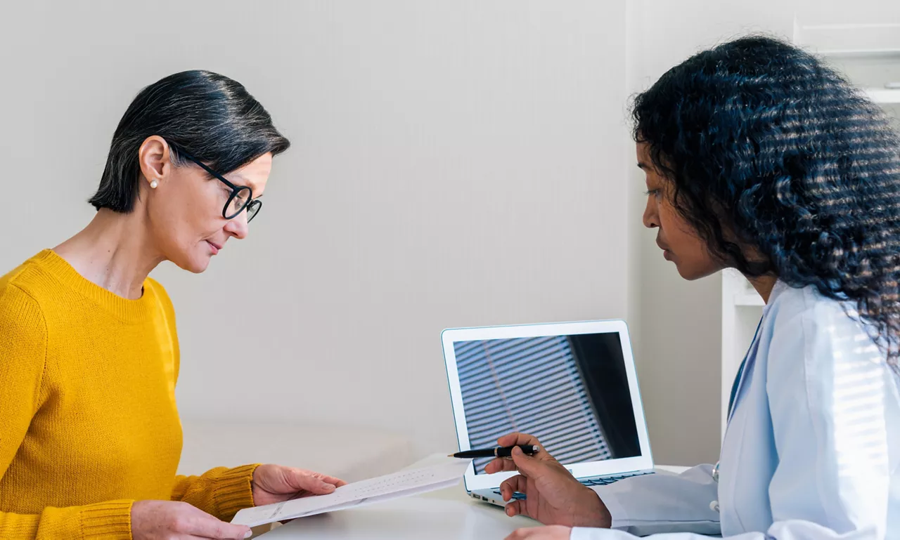 Médica y paciente revisando un documento