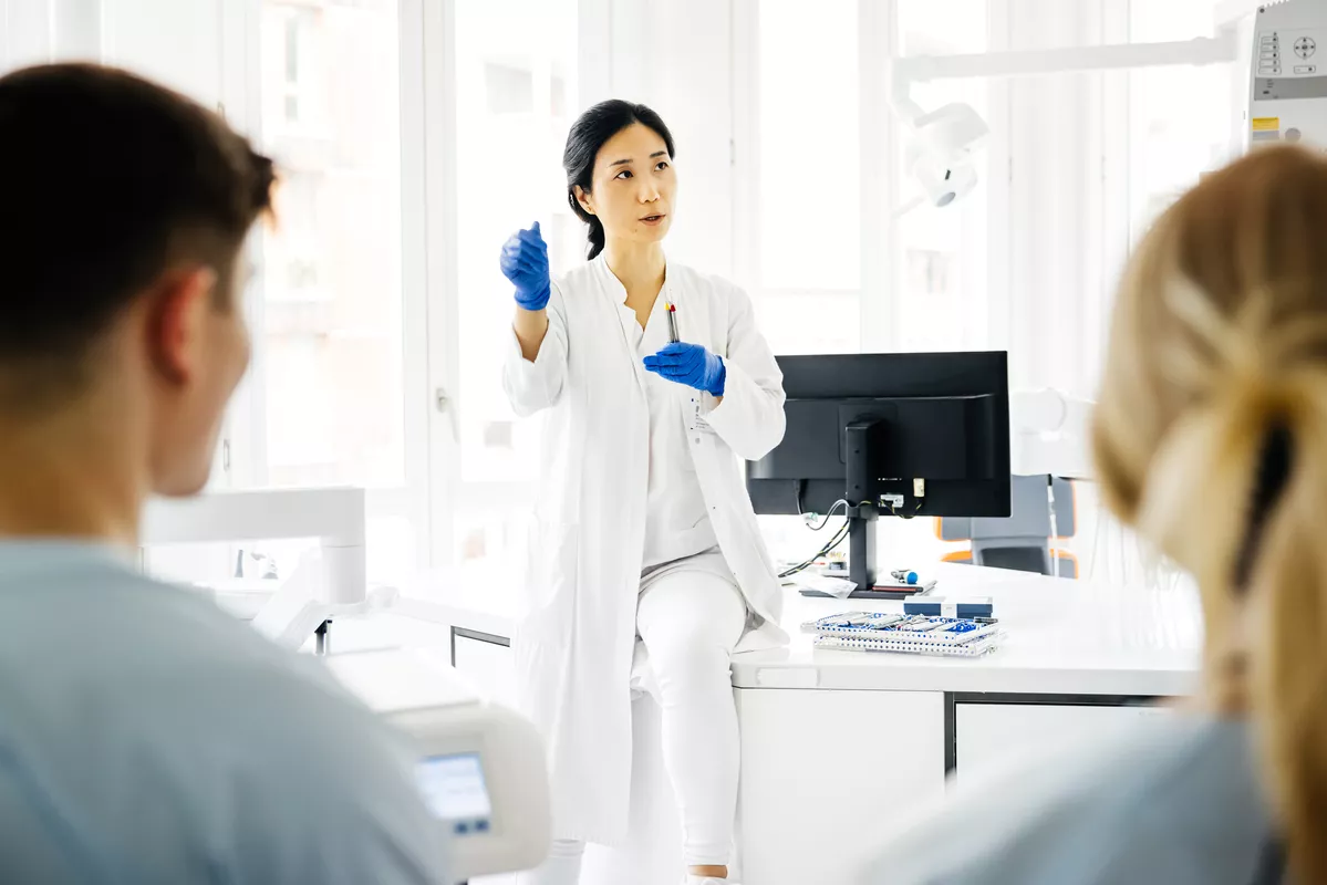 Scientist presenting a tube to students in a lab