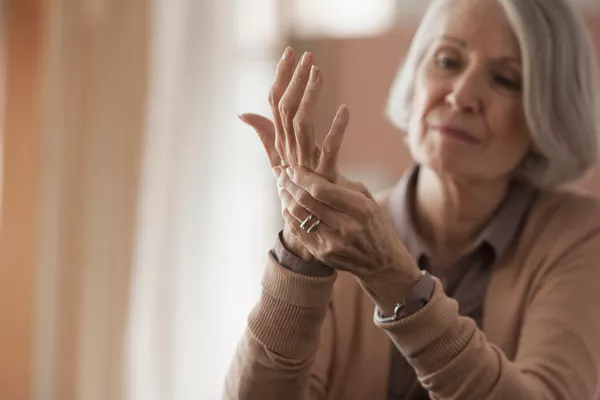 Older woman massaging her aching wrist